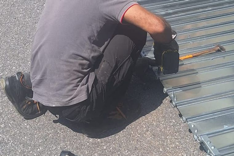 Fabbro al lavoro su un intervento, con il flessibile in mano