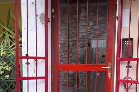 Porta d’ingresso in ferro verniciato rosso con inferriata a protezione