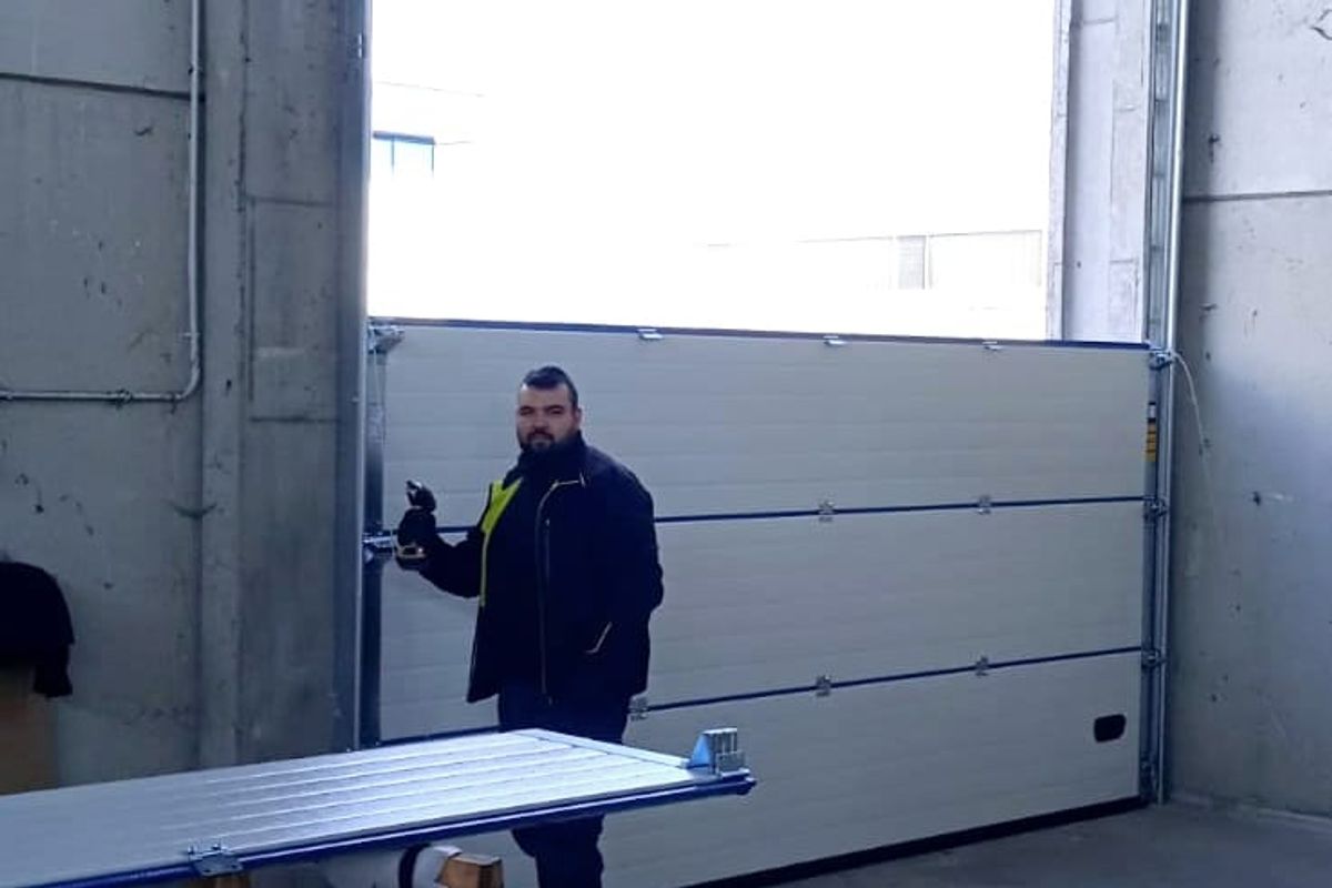Montaggio di un portone sezionale in un capannone, con i pannelli sui cavalletti