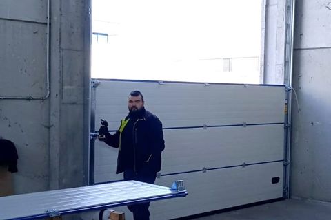 Montaggio di un portone sezionale in un capannone, con i pannelli sui cavalletti